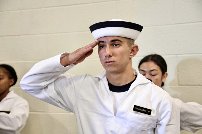 photo of Tyler saluting as he went through processing in Alumni Hall prior to the oath.